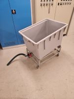 Grauer Behälter auf Rollen, Wäscheeinlegewagen
