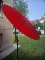 Parasol rouge neuf et pied en granit