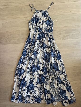 Jolie longue robe blanche à fleurs bleues avec fente sur le 
