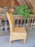 Stühle aus Rattan und Massivholz.