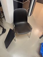 28 schwarze Stapelstühle mit Schreibplatte