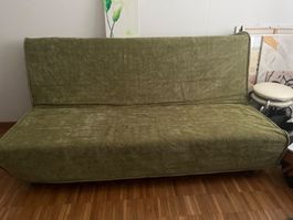 Gemütliches Schlafsofa in Olivgrün.