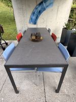 Gartentischgarnitur mit massivem Tisch und farbigen Stühlen