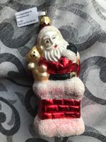 Weihnachtsmann steigt aus Kamin, mit irisierendem Glimmer