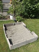 Holzsandkasten mit Sand und Spielzeug