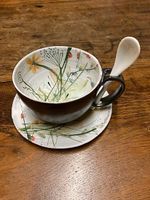 Handbemalte Teetasse mit Unterteller und Löffel.