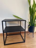 Black metal bedside table with shelf