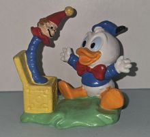 Donald Duck Baby sitzt vor "Jack-in-the-Box" von Bullyland