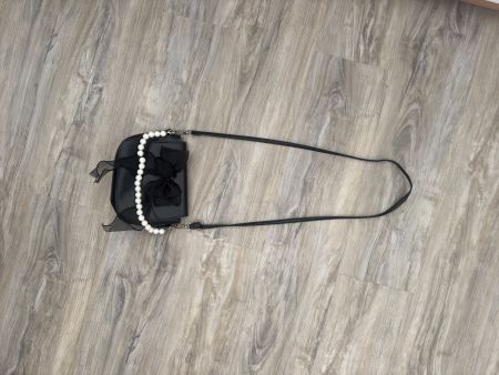 Borsa nera elegante con fiocco e perle