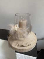 Schönes Dekoglas mit Kerze auf Holzscheibe