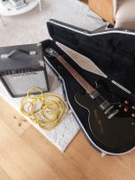 E-Gitarre schwarz mit Koffer und Verstärker