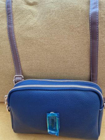 Sac à bandoulière bleu marine avec détails en cuir.