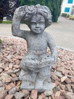 Steinfigur, lesender Junge