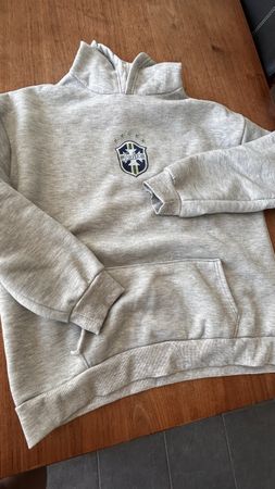 Grauer Kapuzenpullover mit Logo. Perfekt für kühle Tage.
