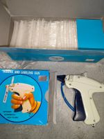 Ältere Pistole und Plastikhaken um Kleider zu beschriften