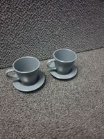 Graue Unterteller mit Kaffee Glas