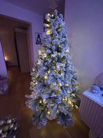 Wunderschöner, schneebedeckter Weihnachtsbaum mit LED-Licht