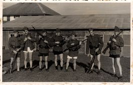 Gruppe Soldaten in Unterhosen mit Jacke und Karabiner