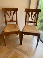Zwei alte Stühle aus Holz mit geflochtener Sitzfläche