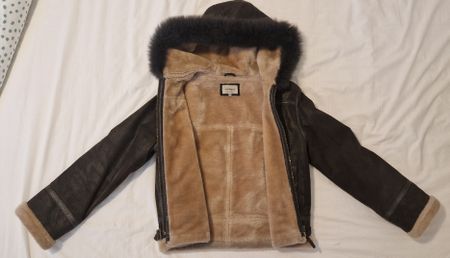 Giacca invernale in pelle con cappuccio e pelliccia.