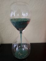 Dekorative Sanduhr mit blauem Sand und Glitzerpartikel