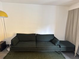 Sofa dunkelgrün mit Chaiselongue mit der Daunenkissen