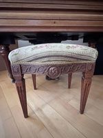 Antiker Hocker mit Stoffbezug und geschnitztem Holzgestell