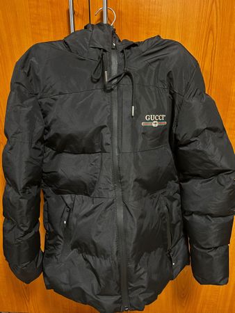 Doudoune Gucci noire d'hiver, chaude et stylée.
