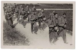 Soldaten marschieren, Mädchen laufen mit, um 1915