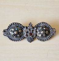 Broche ancienne argentée avec pierres rouges et bleues