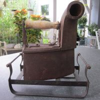 Antikes Kohlebügeleisen mit Kamin auf Bügeleisenschlitten