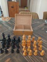 Schachfiguren Set mit Holzkiste schwarz und naturfarben.