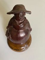 Statue auf einer beschrifteten Dose