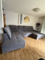 Graues Ecksofa mit Schlaffunktion und Bettkasten für den Her
