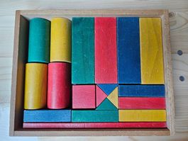 19 div. Holzklötze in Holzkiste, div. Farben, 32x25cm