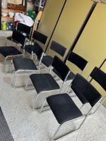 Lot de 9 chaises design avec tissu noir et métal chromé.