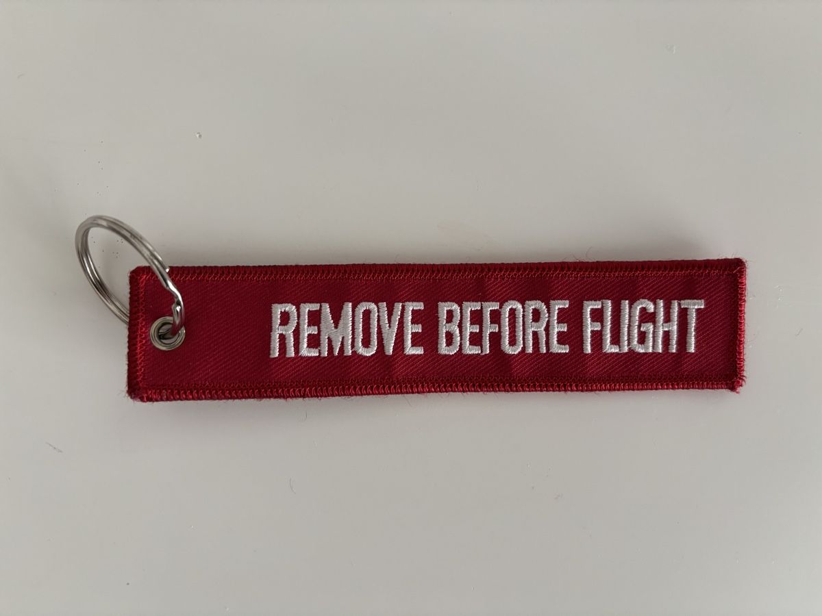 Portachiavi: Schlüsselanhänger "REMOVE BEFORE FLIGHT" rot/weiss – Nuovo e nell'imballaggio originale da Bülach venduto da Karuna