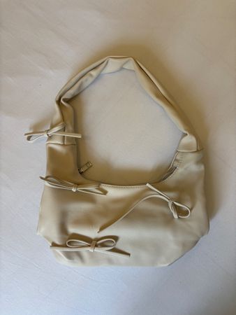 Sac à main beige avec nœuds décoratifs