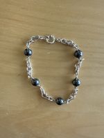 Silberfarbenes Armband mit schwarzen Kugeln, neuwertig.