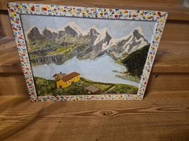 Gemälde, gerahmt, Berglandschaft mit See und Häusern.