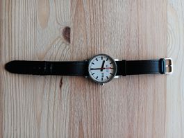 Schwarze Armbanduhr von Mondaine mit SBB Design. 