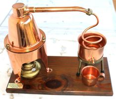 Dekorative Mini-Kupfer-Destille auf Holzsockel