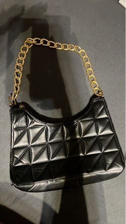 Schwarze Tasche mit goldener Kette