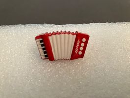 Rotes Miniatur Akkordeon für die Puppenstube, detailgetreu
