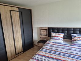 Bett mit elegantem Holzakzent und integrierten Nachttischen