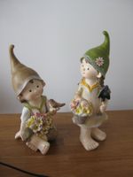 Schönes Pärchen sitzend und stehend mit Blumen