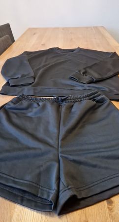 Schwarzer Sportanzug, bestehend aus Shorts und Oberteil 