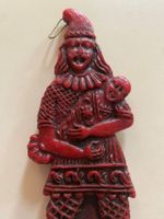 Wachsfigur in traditioneller Kleidung die ein Kind hält.