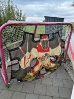 Cage de hockey rouge avec cible d'entraînement