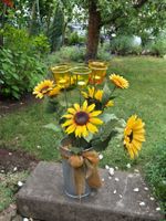 künstliches Sonnenblumen Gesteck mit Gläsern mit Kerzen